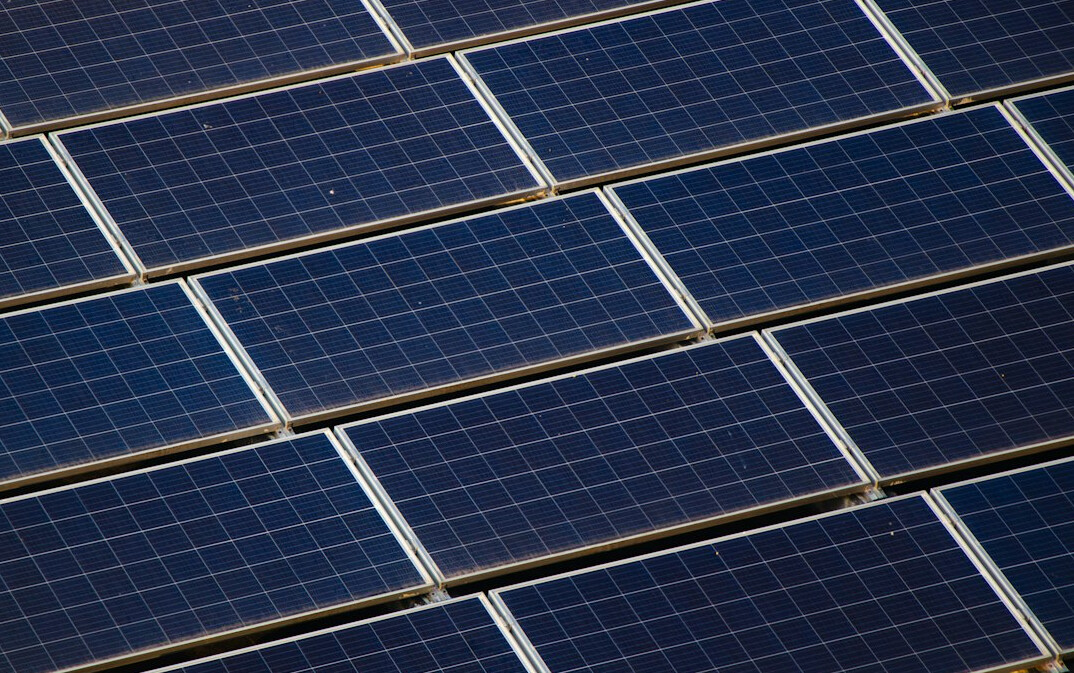 Solar panels with long shadows from a nearby tree in late afternoon